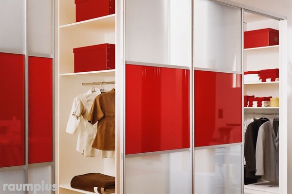 Moderner Einbauschrank mit Schiebetüren in Rot und Weiß, Kleiderstange und roten Aufbewahrungsboxen.