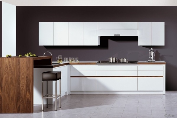 Moderne Einbauküche mit weißen Fronten, dunkler Wand, Holzarbeitsplatte und Barbereich mit Hockern.