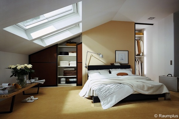 Modernes Schlafzimmer im Dachgeschoss mit großem Dachfenster, Einbauschrank und gemütlichem Doppelbett.