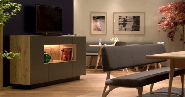 Modernes Wohnzimmer mit Sideboard, Fernseher, stilvoller Sitzbank und dekorativer Wandgestaltung.